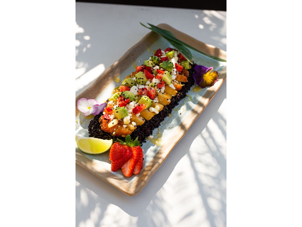 Pane & Trita. Milano. Pollo Samba. Filetto di pollo crunchy al pane panko con salsa samba al mango, avocado, feta sbriciolata, battuta di fragole e sesamo colorato è servito con riso venere profumato.