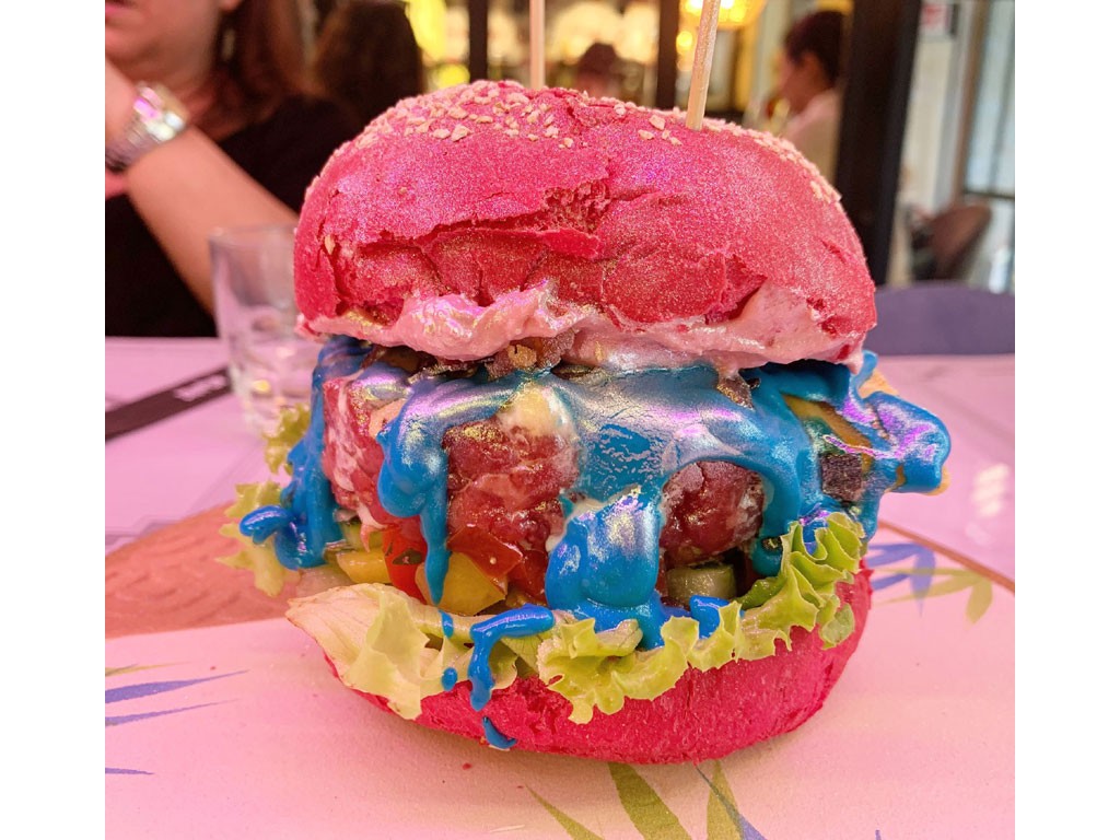 Pane & Trita. Milano. UNIPORCO. Pane rosa glitterato con tartare di Black Angus, stracciatella, crispy bacon pork, cremoso pink alla barbabietola, chips di tortillas, pico de gallo e maionese arcobaleno. Foto Credits: Sara Bosco.