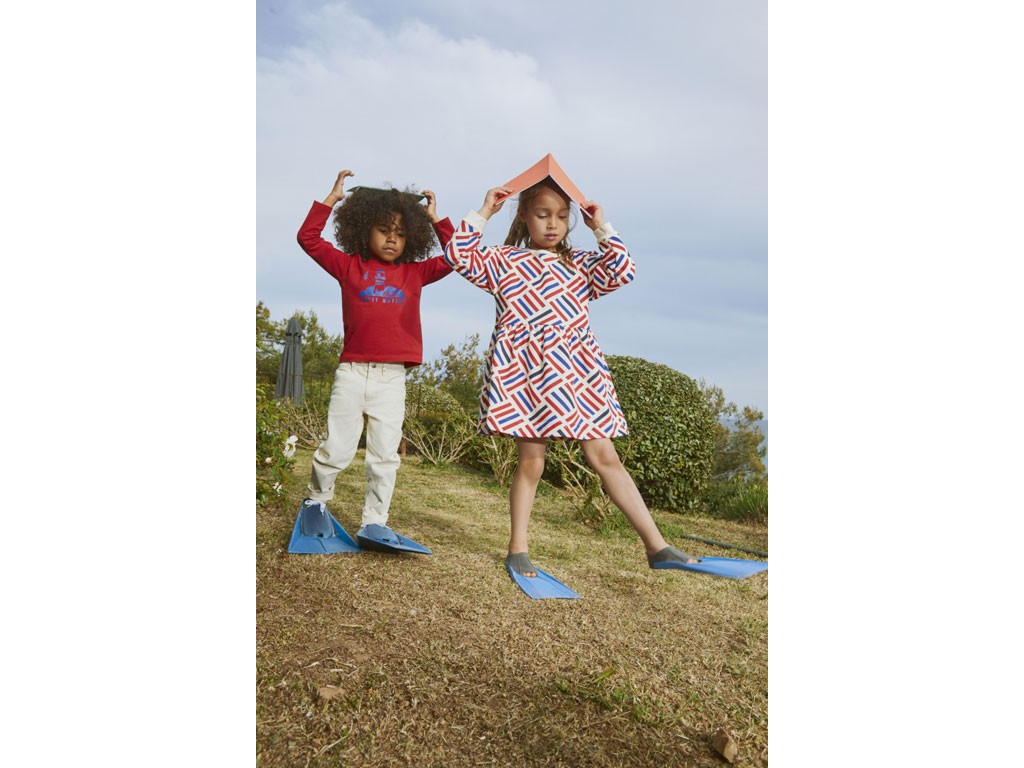 Petit Bateau. Collezione Autunno/Inverno 22-23. Per lei: abito a maniche lunghe bebè in felpa di cotone con stampe grafiche. Apertura con bottoni automatici sullo scollo. Prezzo: da euro 40,00. Per lui: t-shirt bambino a maniche lunghe serigrafata in jersey in cotone. Disponibile nelle tonalità: bianco, blu, grigio e rosso. Prezzo:da euro 22,00.
