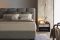 Flou. Letto matrimoniale Majal. Design Carlo Colombo. Il tessuto è l'elemento predominante nelle forme geometriche della grande e morbida testata. Il piano di riposo è a doghe regolabile ma disponibile anche con rete a movimento elettrico. Il rivestimento è in tessuto o pelle sfoderabile.