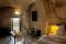 Sextantio Albergo Diffuso Le grotte della Civita. Grotta 3 Superior Room, 70mq.. La finestra d'accesso è in ferro battuto lavorato a mano. Lavello in pietra e vasca da bagno nella zona relax.