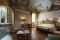 Hotel Alla Posta dei Donini. La camera da letto più prestigiosa della residenza d’epoca. Il soffitto, attribuito alla scuola di Francesco Appiani, affrescato con degli elementi architettonici, elementi floreali e tratti di cielo con angeli. La stanza in passato era la sala da pranzo dei Donini.