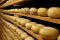 Forme d’Arte. Una stanza per la stagionatura del pecorino toscano. Le forme riposano su assi di legno.
