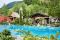 Hotel Quelle Nature Spa Resort. Nell'immagine la Infinity Pool, la Cappella dedicata a San Cristoforo e la Ruota del Mulino.