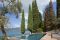 Isola Verde Piscine. Siamo all’interno di un parco che guarda sul Garda. La ristrutturazione di una villa di fine ‘800 e la riqualificazione di tutta l’area verde è stata l’occasione per inserirvi, con discrezione, una piscina realizzata con materiali antiriflettenti. In questo modo se ne è abbassato il grado di rifrangenza che avrebbe potuto determinare alterazioni dal punto di vista paesaggistico. La struttura della piscina è in lastre di acciaio, rivestita in Mortex® Etanche & Color, materiale impermeabilizzante, antiriflettente, a finitura opaca. I materiali lapidei della piscina sono in Giallo d’Istria e la zona relax è pavimentata con listoni in legno. Progettista: architetto Luigi Bruno.