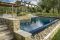 Piscine Castiglione. Circondata dalla natura toscana e da colline di ulivi, questa villa con piscina progettata dall’architetto Mario Baldini si integra perfettamente al contesto naturale. Lo specchio d’acqua - che misura 15 x 5 metri con una profondità che raggiunge i 2,40 metri sul lato provvisto di trampolino - esibisce forme geometriche declinate ad accomodare la pendenza naturale del terreno. Sfoggia infatti un bordo a cascata, una particolare soluzione di bordo a sfioro adatta per terreni con dislivello, con griglia ribassata rivestita da ciotoli in pietra locale.