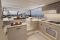 Bénéteau. Modello Monte Carlo 52. Il salone. Ampio spazio conviviale, area cucina collegata al pozzetto e postazione di guida rialzata. Protagoniste le ampie vetrate che regalano una visuale del mare a 360°. La visuale da poppa verso prua.