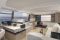 Bénéteau. Modello Monte Carlo 52. Il salone. Ampio spazio conviviale, area cucina collegata al pozzetto e postazione di guida rialzata. Protagoniste le ampie vetrate che regalano una visuale del mare a 360°. La visuale da prua perso poppa.