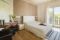 Agriturismo Corte Lantieri. Camera Nike. Suite matrimoniale, dedicata alla Dea della Vittoria, composta da camera e salotto con divano/letto. Grandi dimensioni, luminosa con doppio affaccio e balconata con vista panoramica su vigneti e colline. Soffitto con grandi travi in legno e arredi eleganti e moderni.