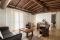 Agriturismo Corte Lantieri. Camera Nike. Suite matrimoniale, dedicata alla Dea della Vittoria, composta da camera e salotto con divano/letto. Grandi dimensioni, luminosa con doppio affaccio e balconata con vista panoramica su vigneti e colline. Soffitto con grandi travi in legno e arredi eleganti e moderni.