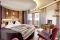 Hotel Quelle Nature Spa Resort. La Camera Romantic Fire (40mq.), arredamento in legno di cirmolo, stufa in maiolica, bagno e balcone.