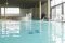 Monticello SPA.Nella piscina interna, con acqua riscaldata a 33°, ci si rilassa su lettini ergonomici immersi. Si eliminano le tensioni sotto energiche cascate cervicali, si nuota controcorrente e ci si affida ai flussi degli idromassaggi.