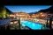 Hotel Quelle Nature Spa Resort. La Infinity Pool by night. All'interno della struttura ci sono sette piscine in e outdoor, una grotta salina, vasche idromassaggio all'aperto e un laghetto naturale.