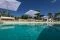 Tenuta del Lauro. Valle d’Itria, Locorotondo. Puglia. Una veduta della piscina in pietra circondata da ulivi secolari, allori e piante di fico.