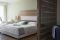 Lefay Resort & SPA Lago di Garda. Letto e zona living della Exclusive Suite. La camera articolata in 83 mq. regala la libertà di un living room privato, una Jacuzzi vista lago e di una serie di servizi esclusivi.